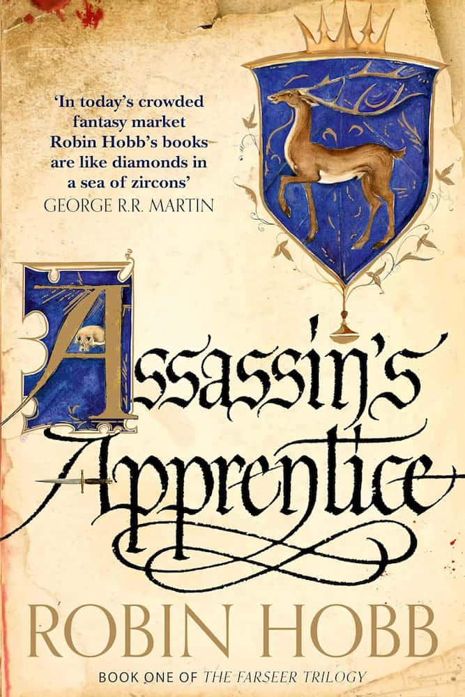 Book cover of 'Assassin's Apprentice' by Robin Hobb with a shield emblem and quote from George R.R. Martin.